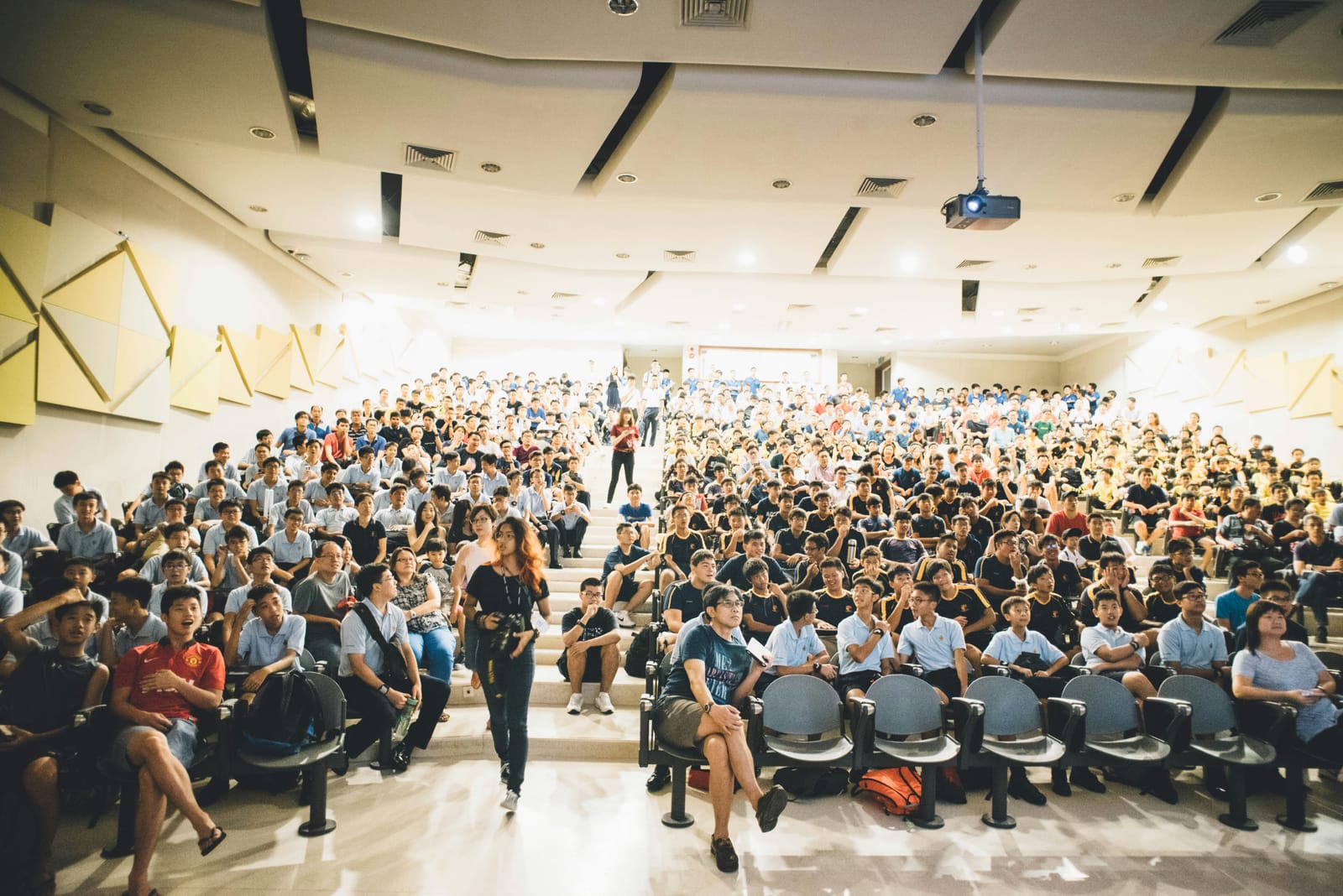 A large audience seated in a conference auditorium