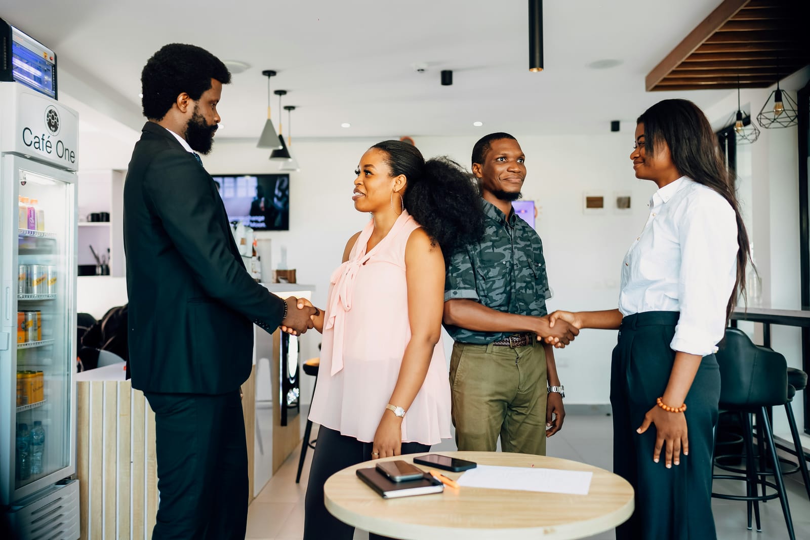 A diverse group of colleagues welcoming someone with a handshake