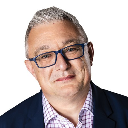 Philip Giles smiling, with short grey hair and dark-rimmed glasses, in a navy jacket and checked shirt