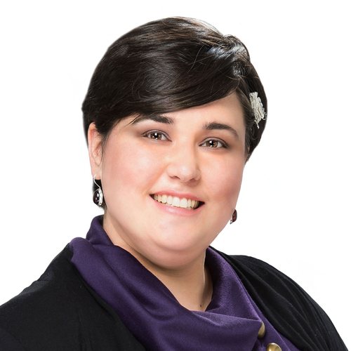 Alli Chernoff, smiling, with short dark hair, in a purple scarf and black sweater